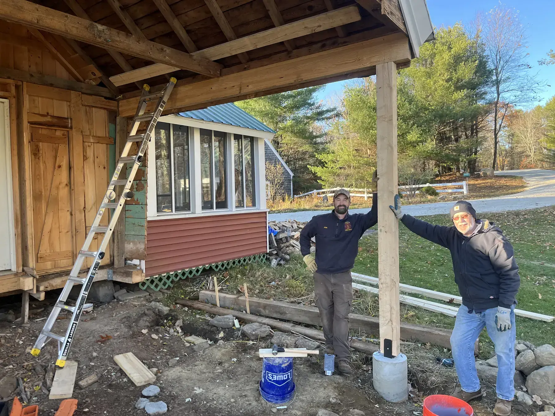 Josh Heck and Dick Bragg standing under a newly framed structure at South Road Farm